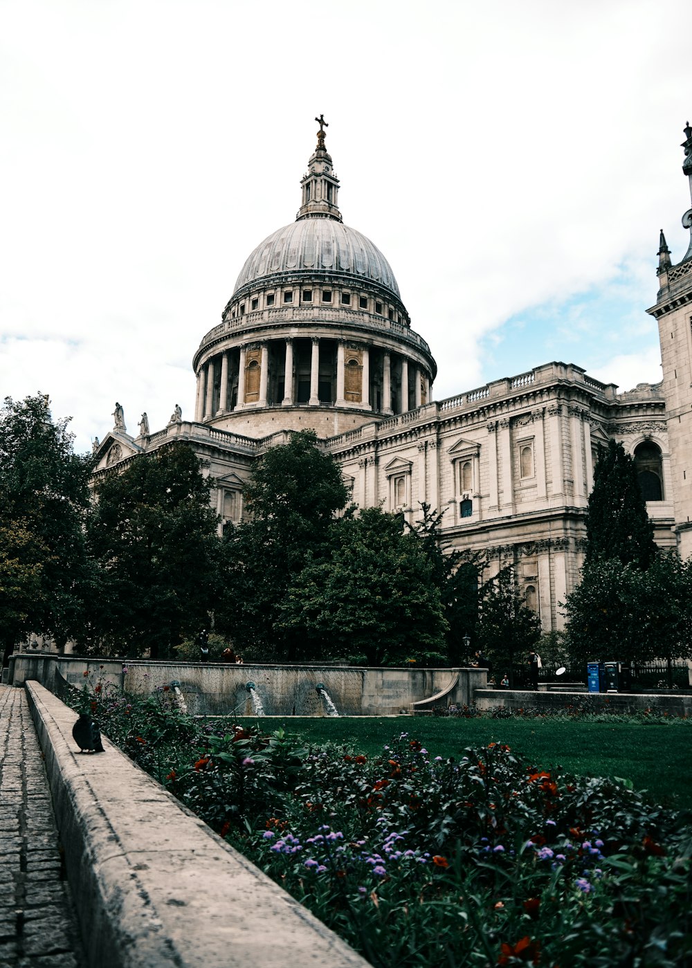 a large building with a dome and a garden in front of it