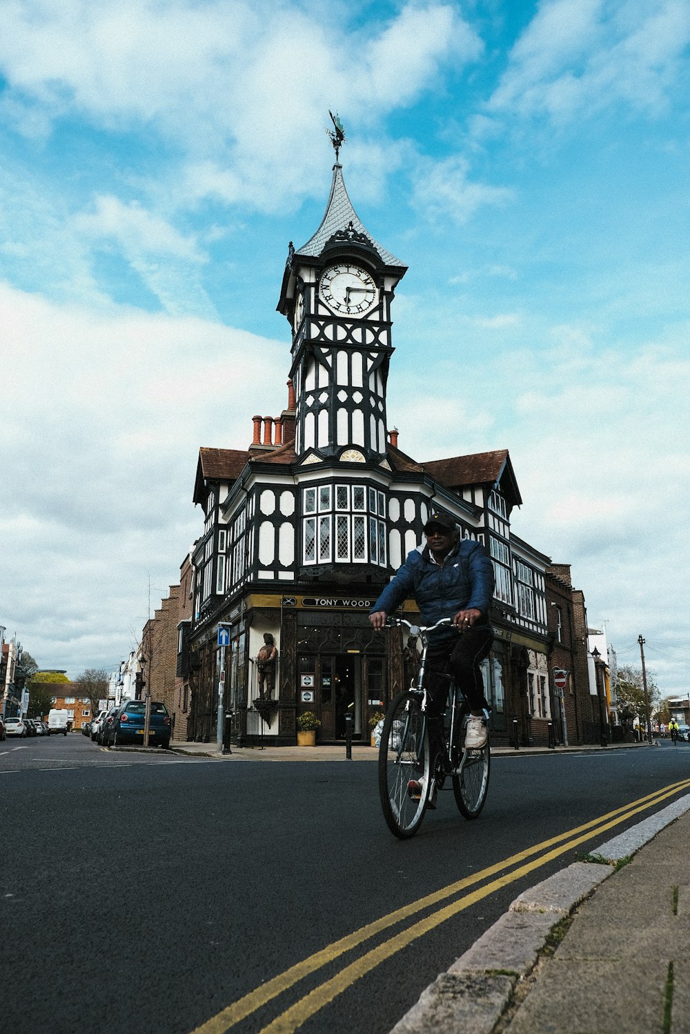 a person riding a bicycle in front of a clock tower