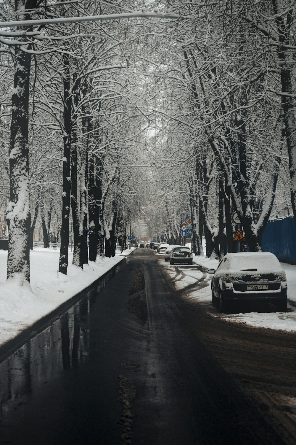 a road with snow on the side and cars on the side