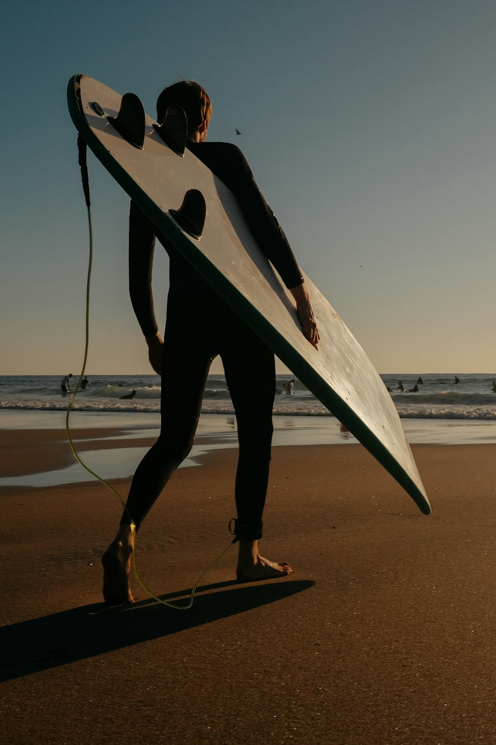 a person holding a surfboard on a beach