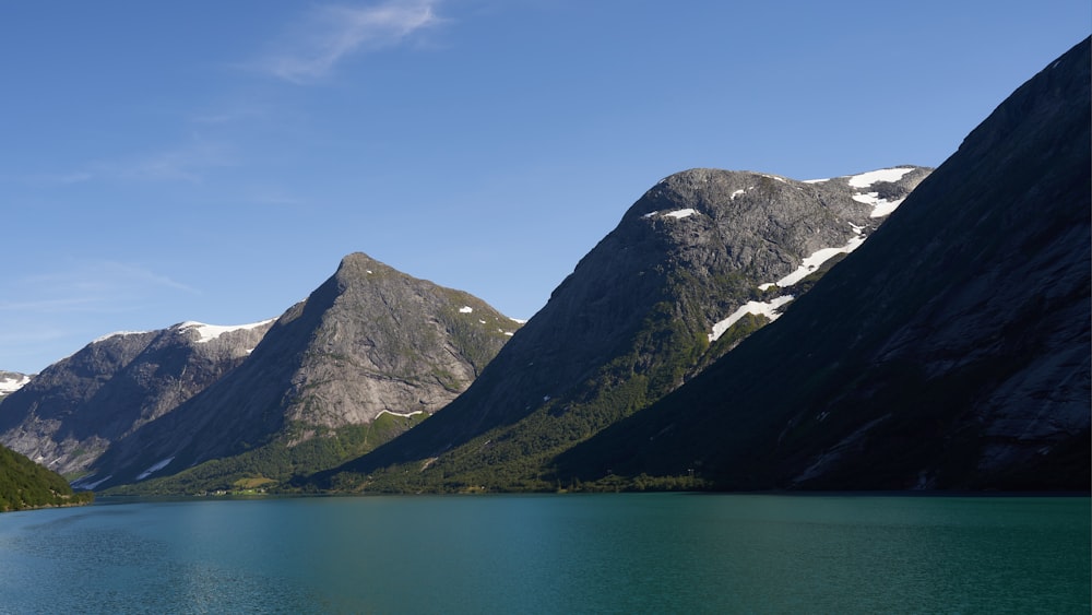 a body of water with mountains in the back