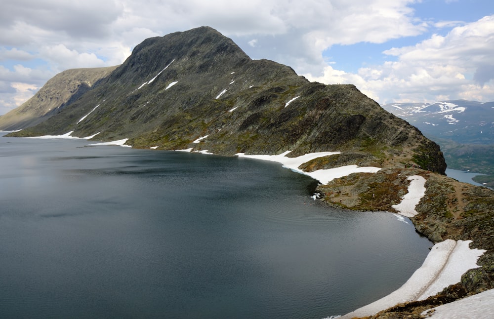 a body of water with mountains in the back