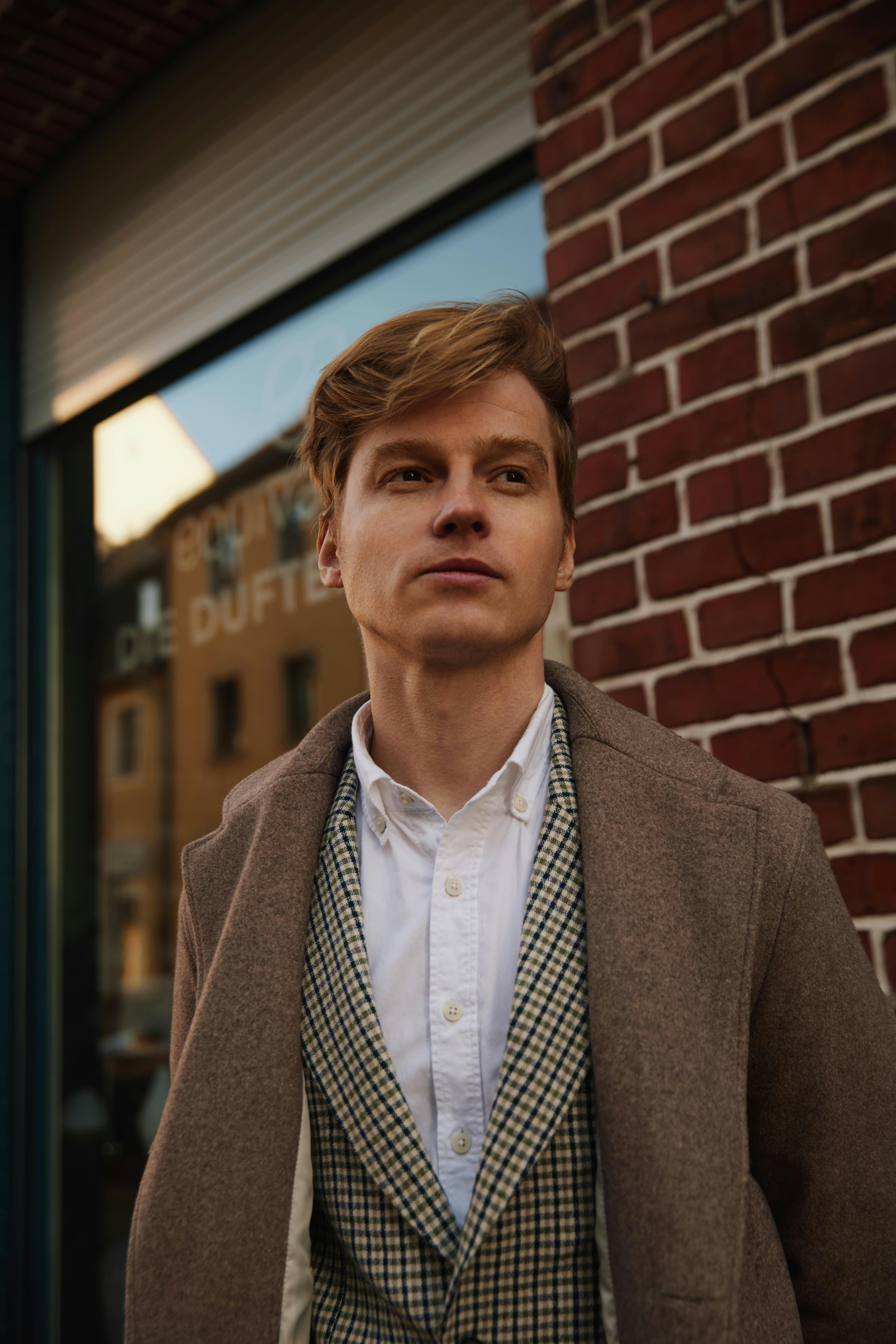 A man standing in front of a brick wall photo – Free Germany Image on ...
