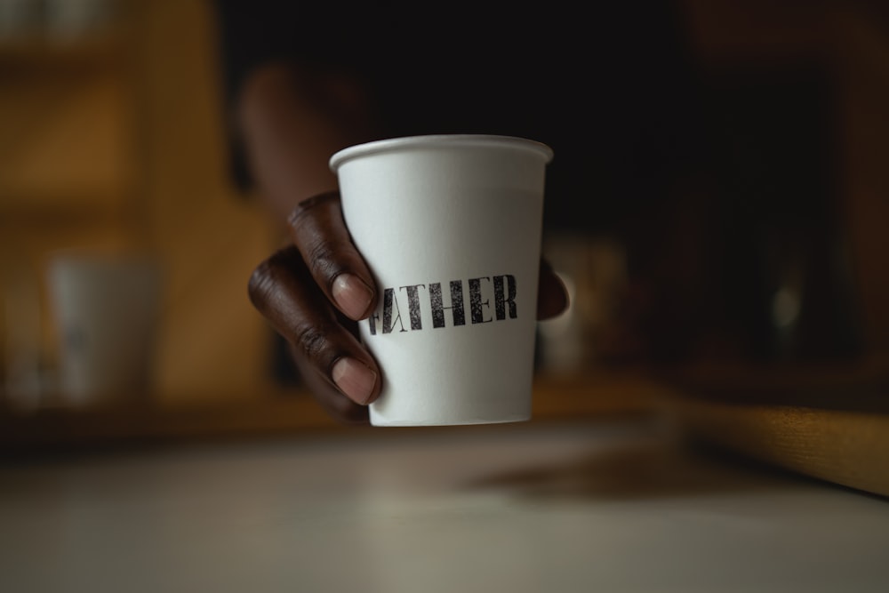 a hand holding a coffee cup