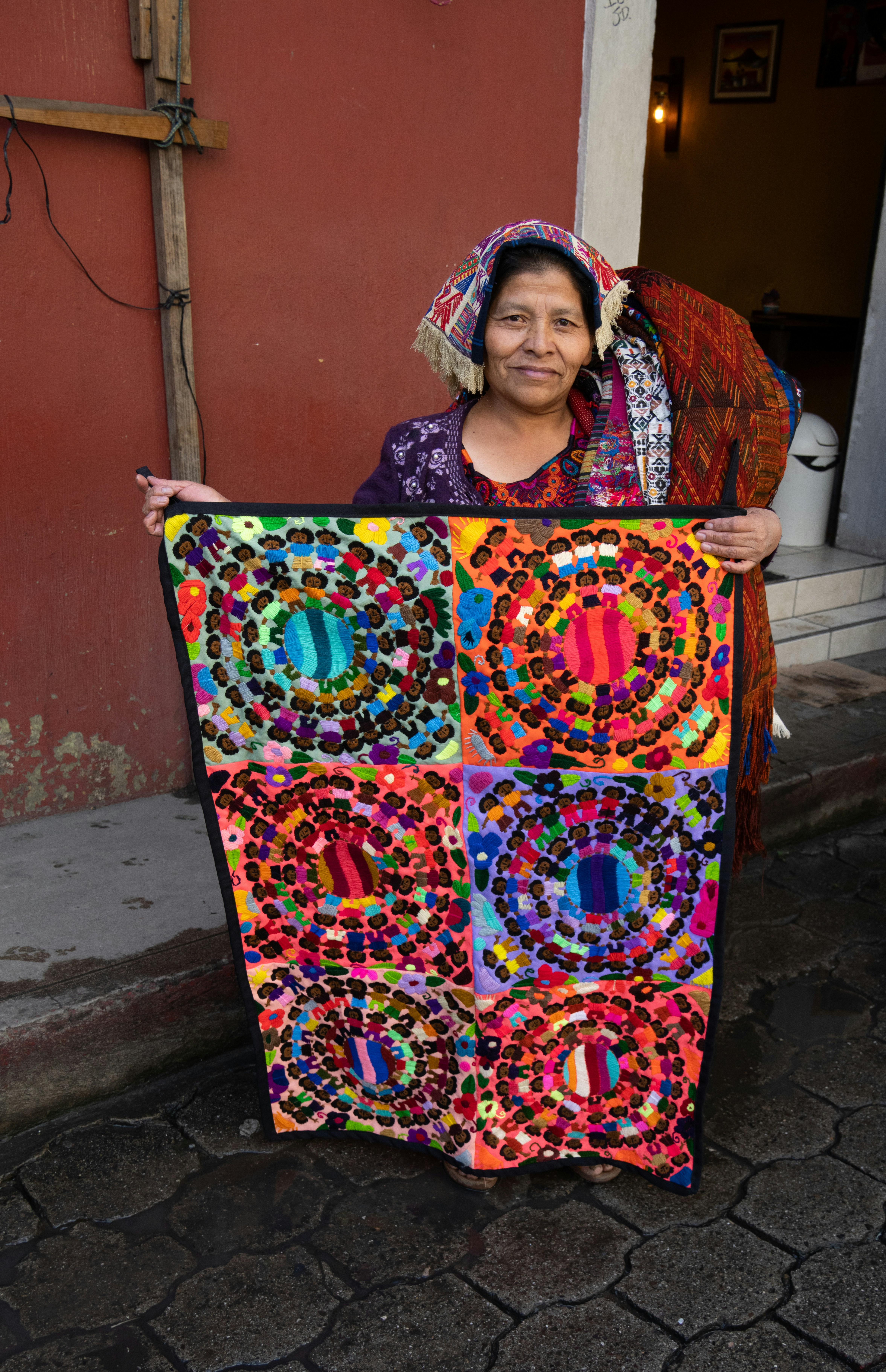 Smiling artisan proudly holding a finished handmade textile piece