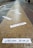 Multiple pieces of white paper with black text are scattered along a textured, yellow-tinted pedestrian path. The path is bordered by a gray cobblestone sidewalk on one side and a brown paved walkway on the other. In the background, a pair of feet in boots can be seen walking away.