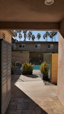 a house with a gate and a patio with plants and trees