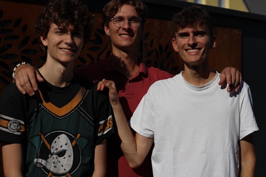 Three brothers standing proudly in front of their flour mill, symbolizing family and dedication.