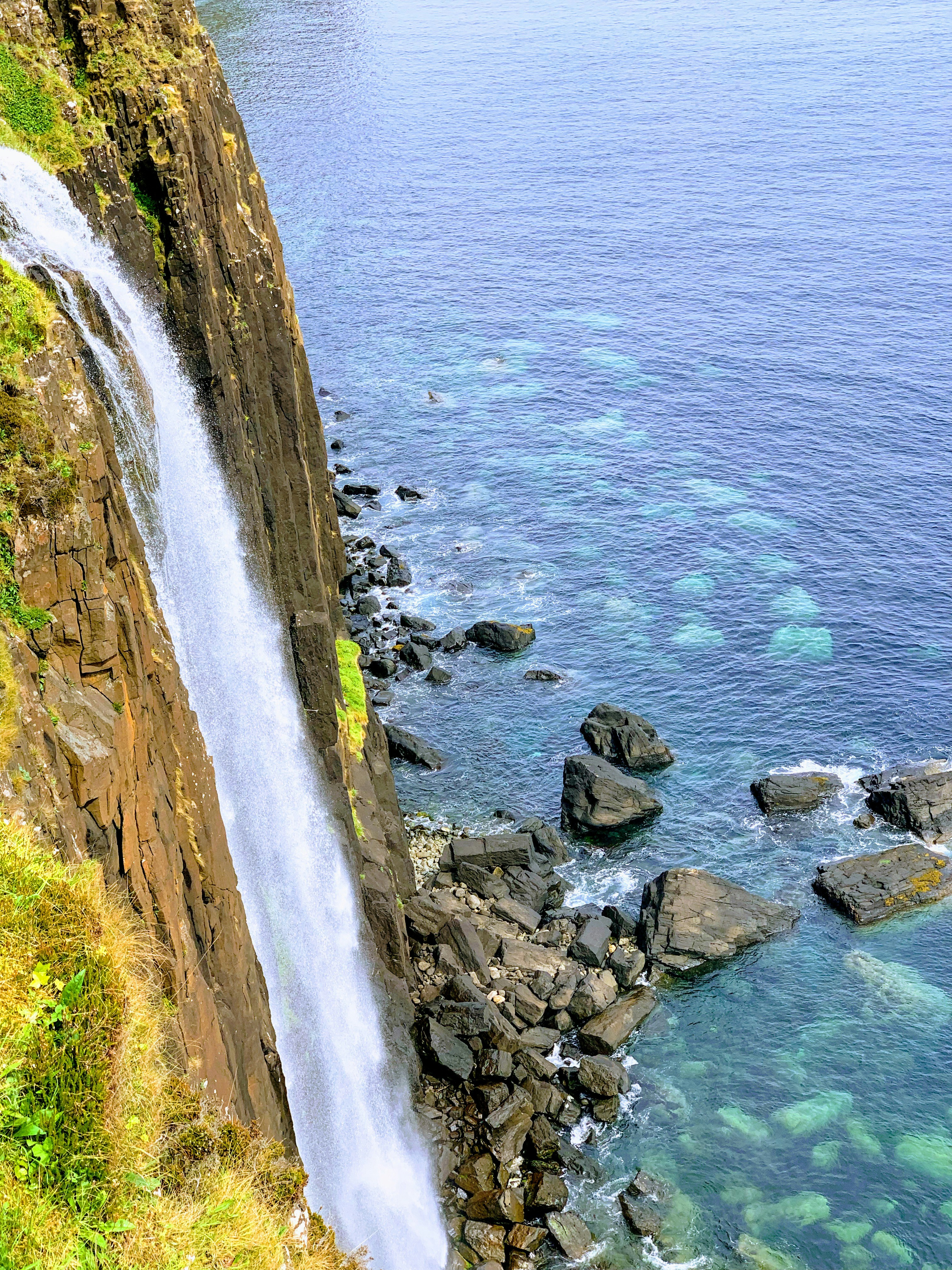 a rocky shore with a body of water in the background