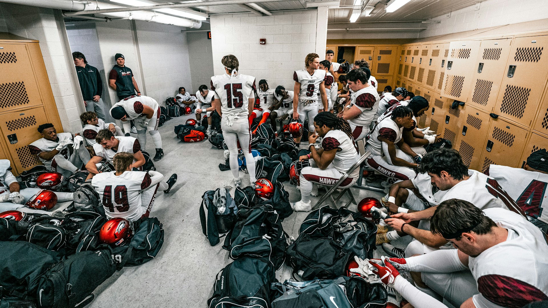 a group of people in a room with many helmets