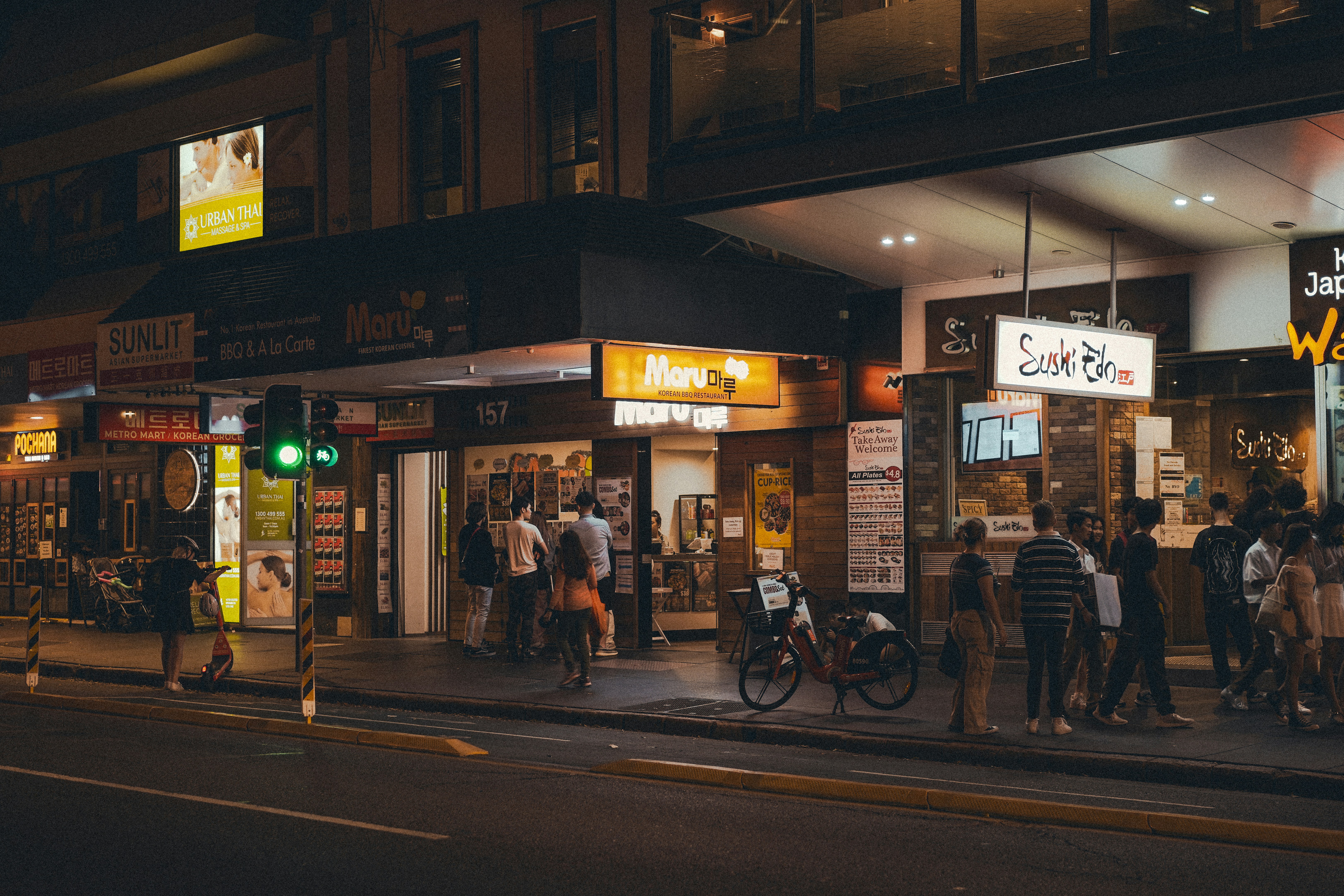 a group of people stand outside a store, 