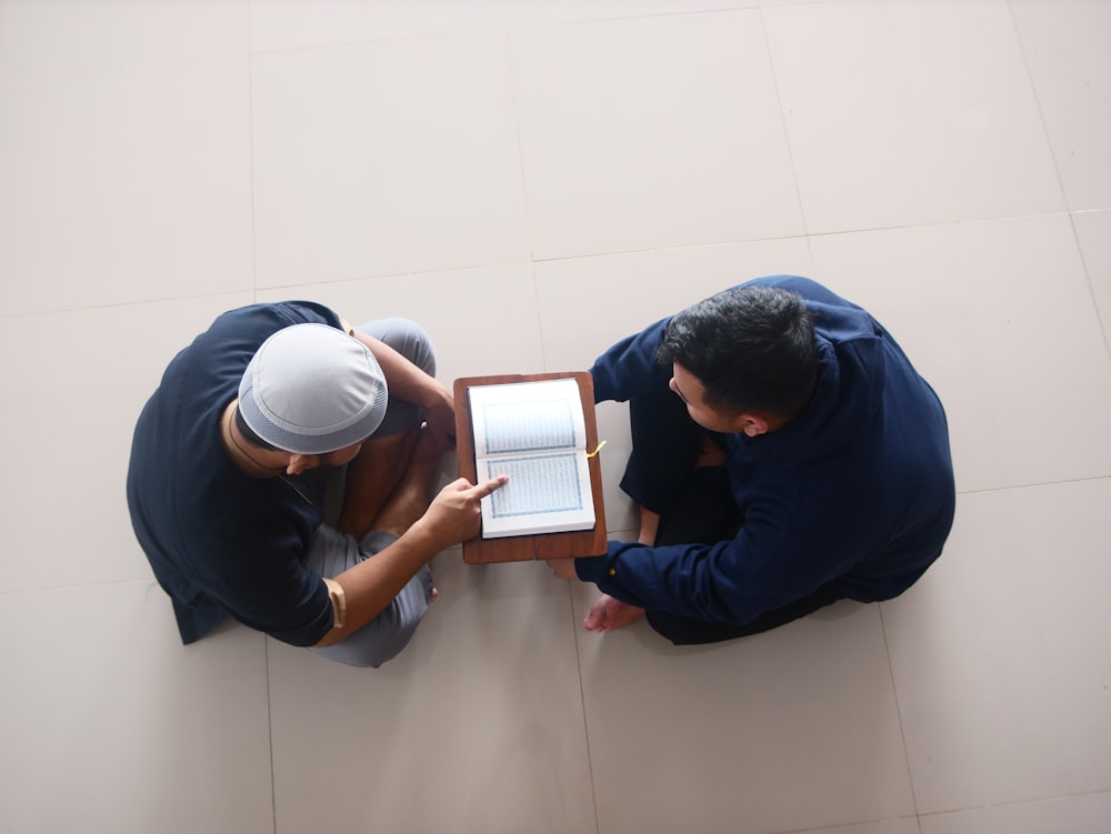 a couple of men looking at a tablet