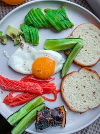 A beautifully arranged plate of vegan dishes featuring avocado toast and vibrant fruit.