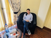 A patient comfortably explaining their symptoms using klarforlegen while sitting in a cozy living room.