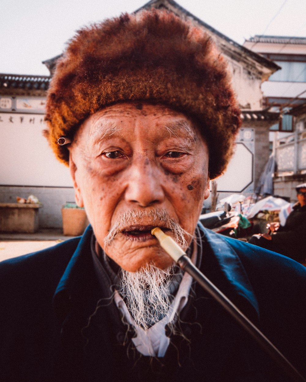 a man with a hat smoking a cigarette