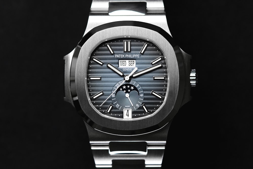 a silver watch with a black face