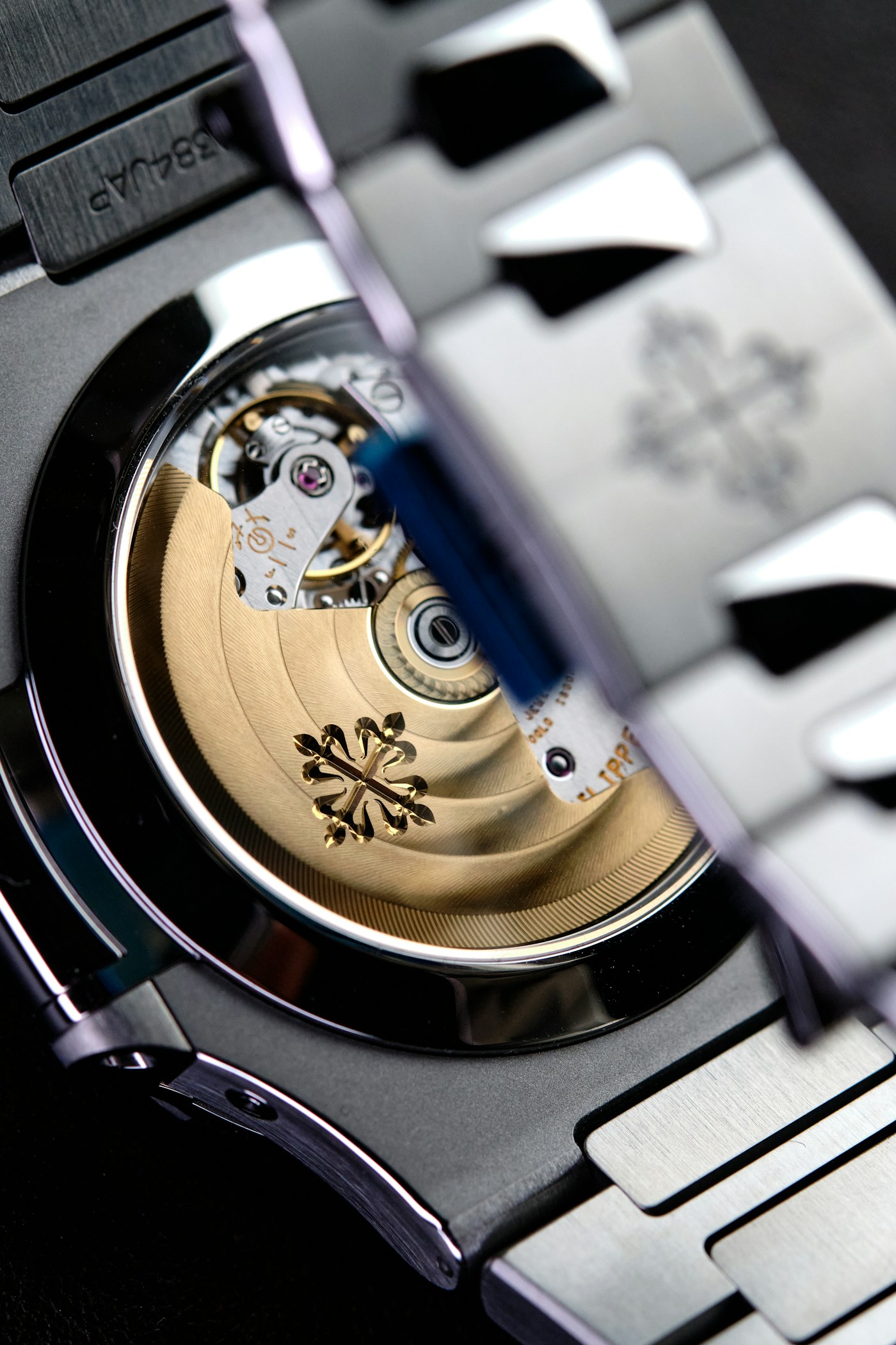 Patek Philippe Nautilus gold movement through sapphire caseback close-up