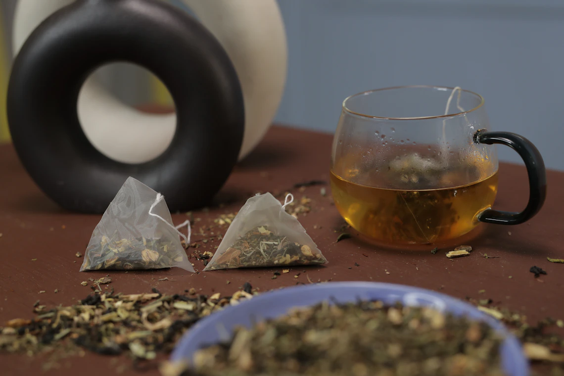 A glass of tea and a ceramic mug arranged together on a table.