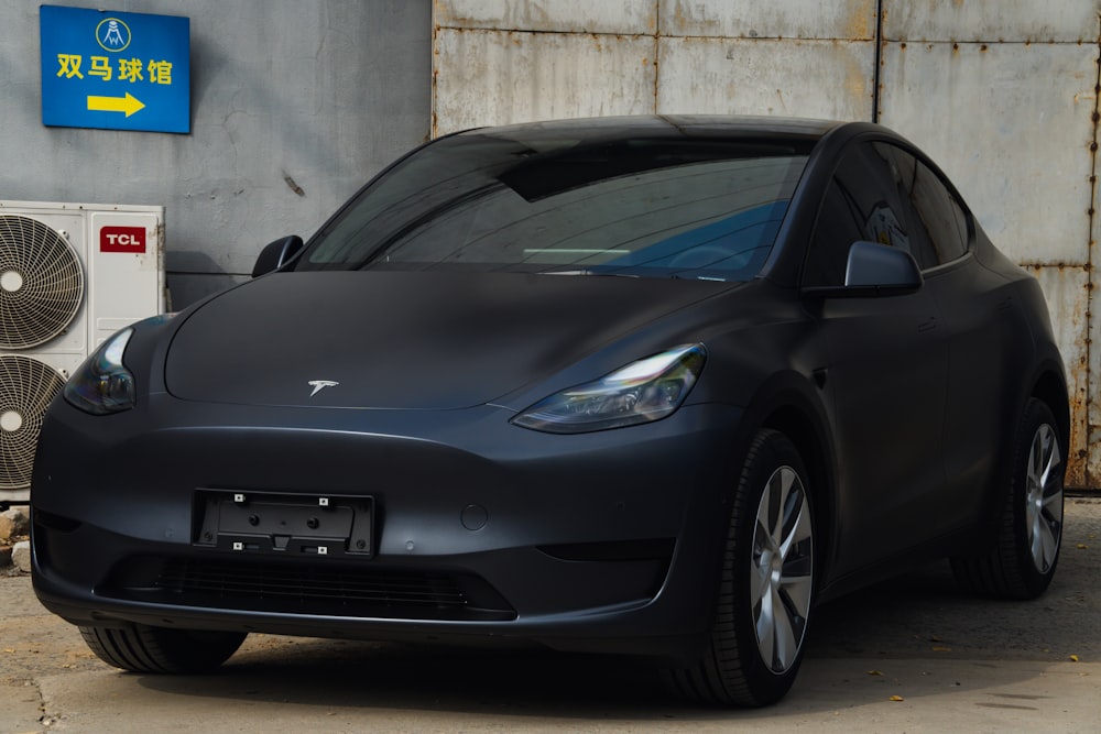 a black car parked in front of a garage