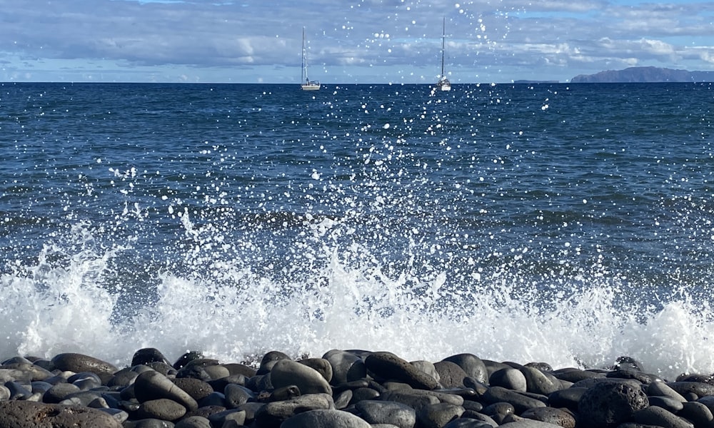 uma praia rochosa com barcos na água