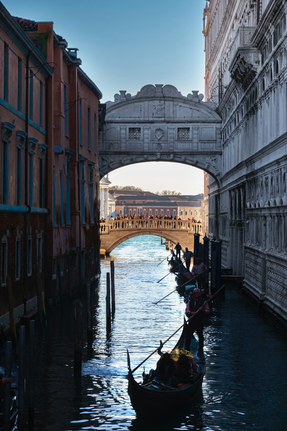 a boat on a canal with Bridge of Sighs in the background