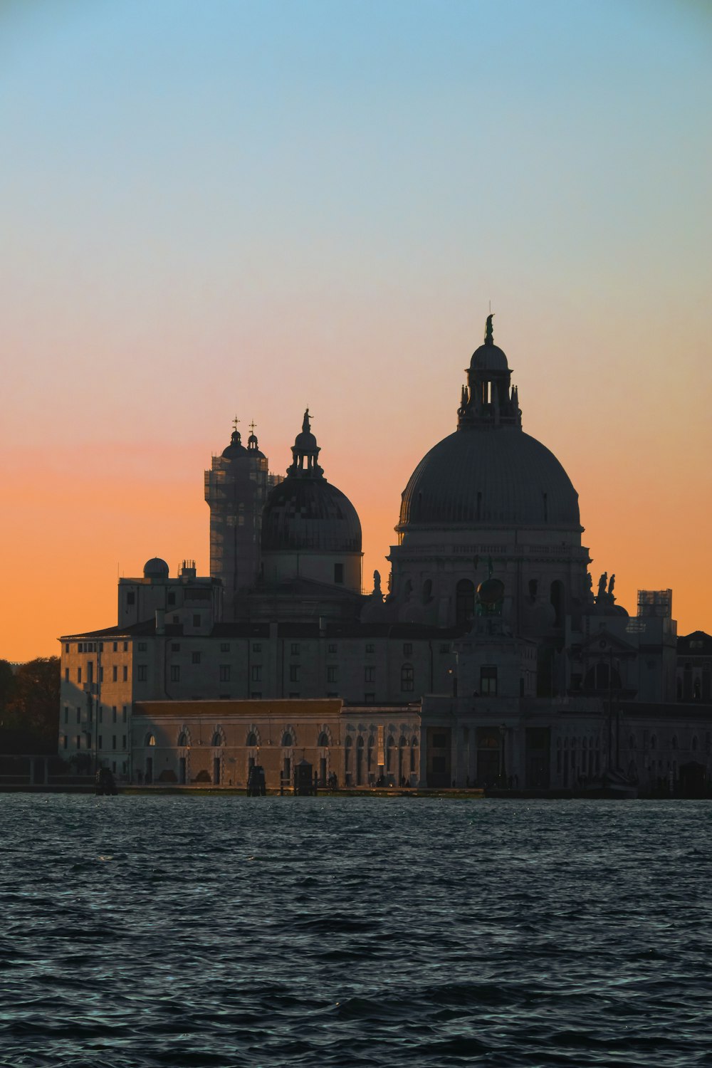 a large building with domed roofs by water