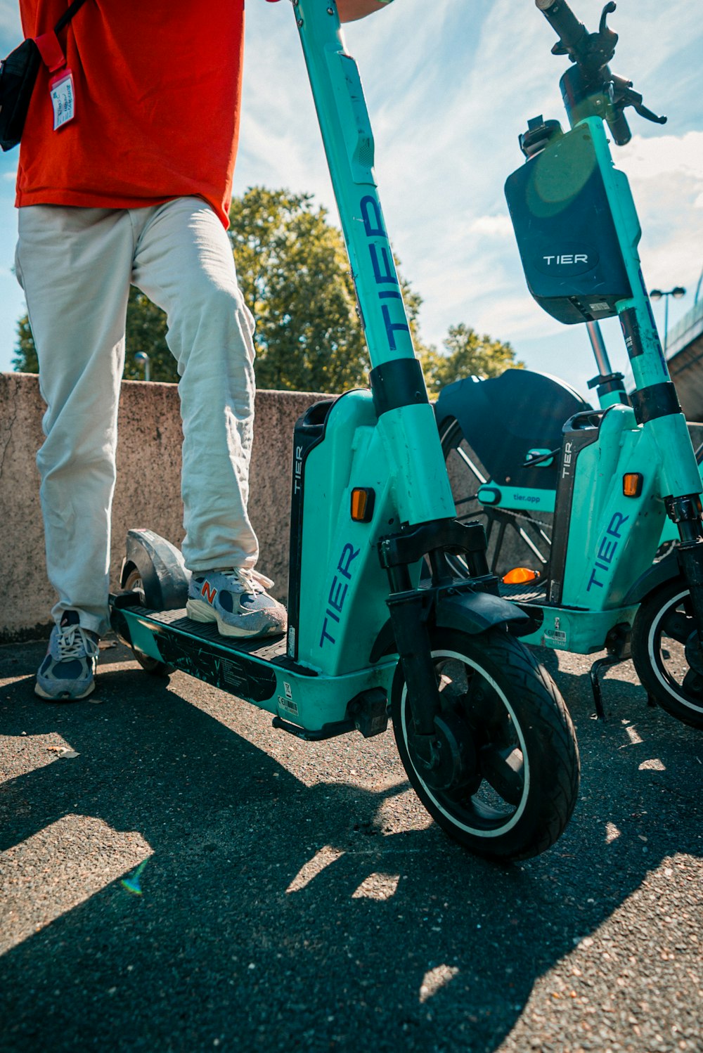a person standing on a green and blue scooter