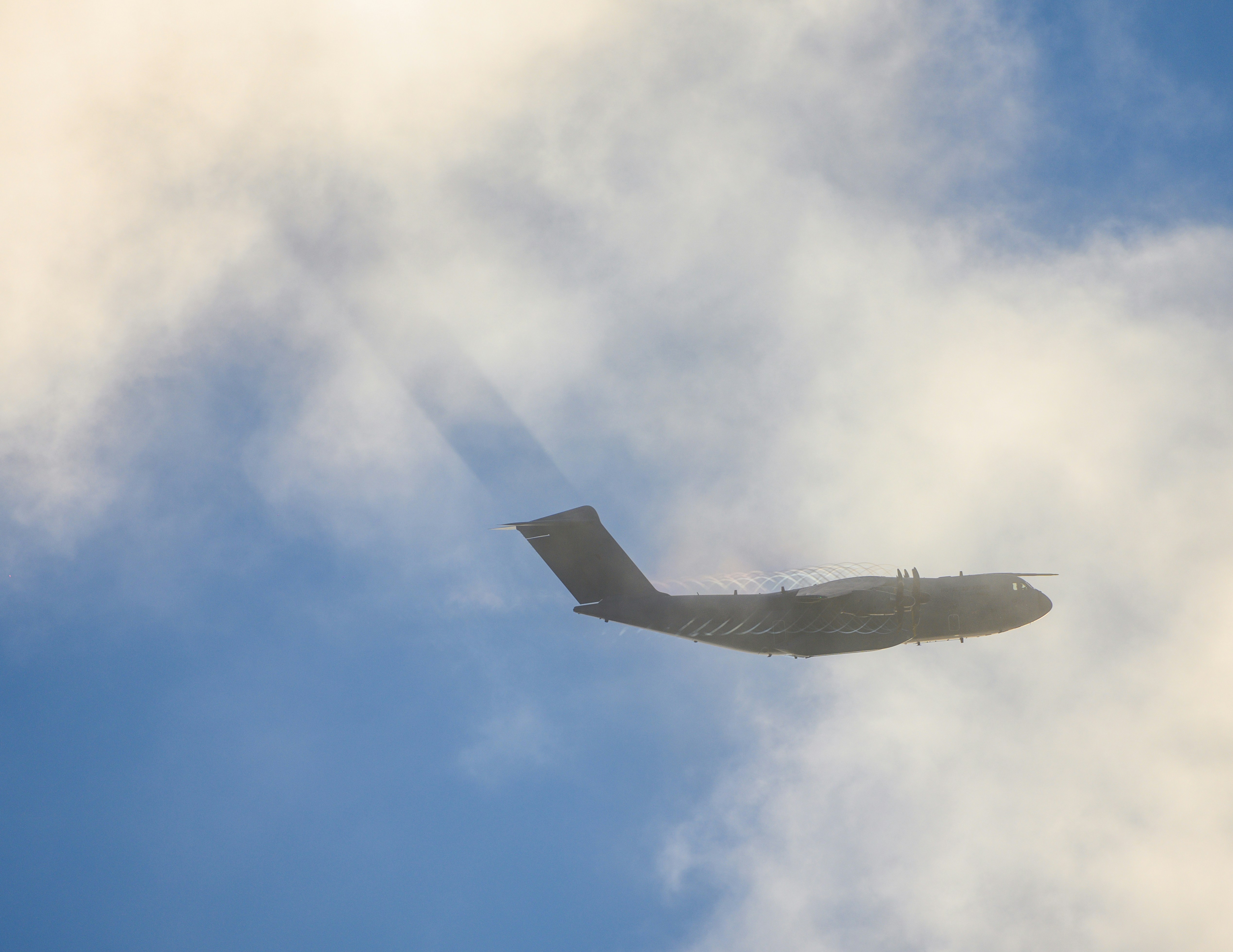 a jet flying in the sky, a400 plane through the clouds