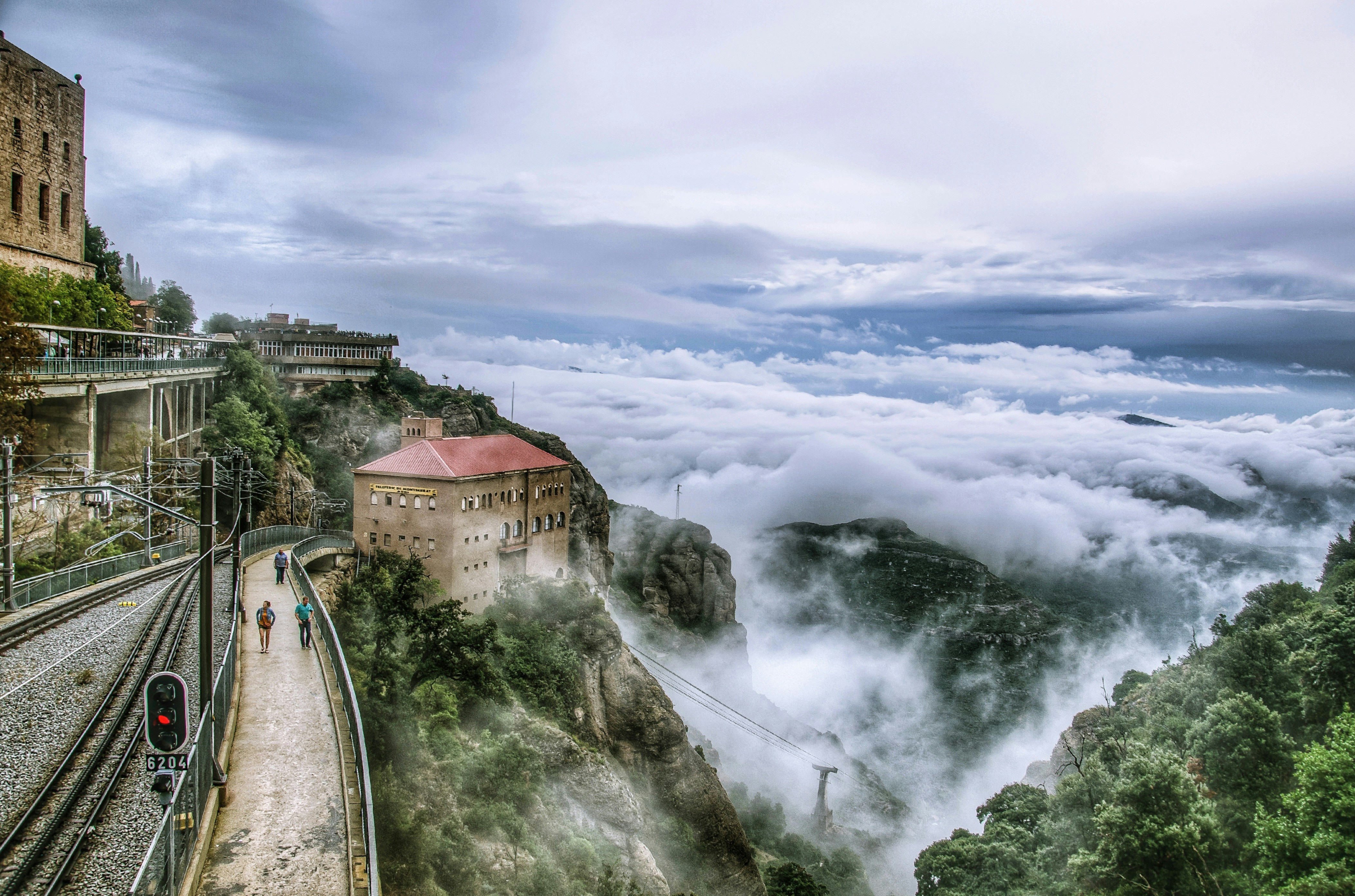 a train track with a building on it and trees around it, At Montserrat Monastery, Catalonia, Spain.