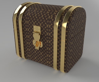 A luxury chest with a curved top, adorned with a recognizable brown and gold monogram pattern. The chest features gold-colored metal bands and a central lock, giving it an elegant and sophisticated look.