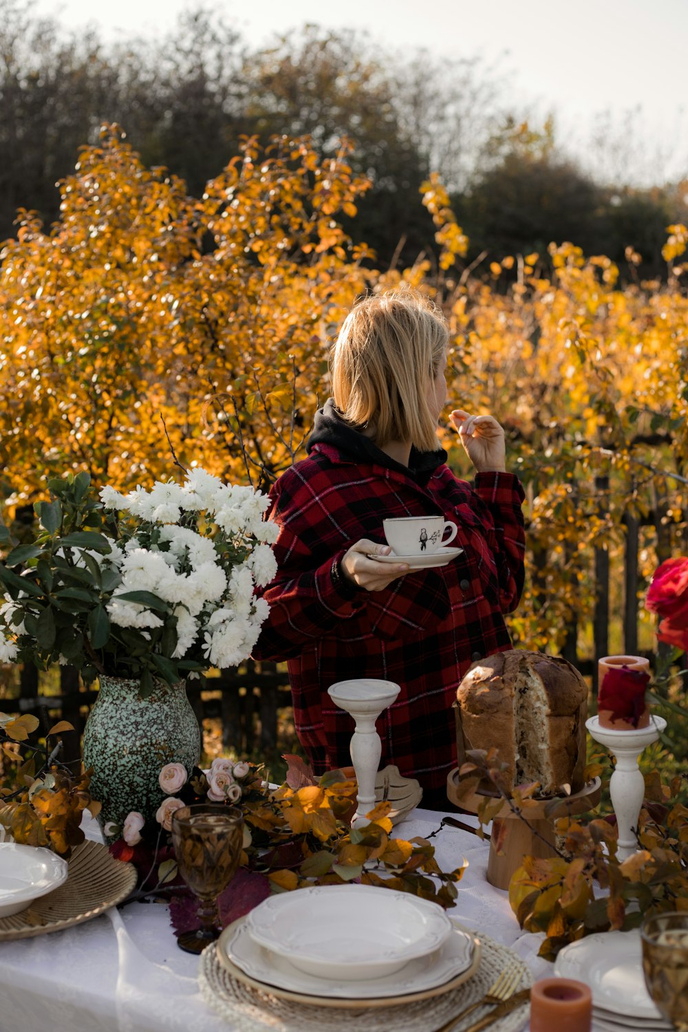 a person standing in front of a table with flowers