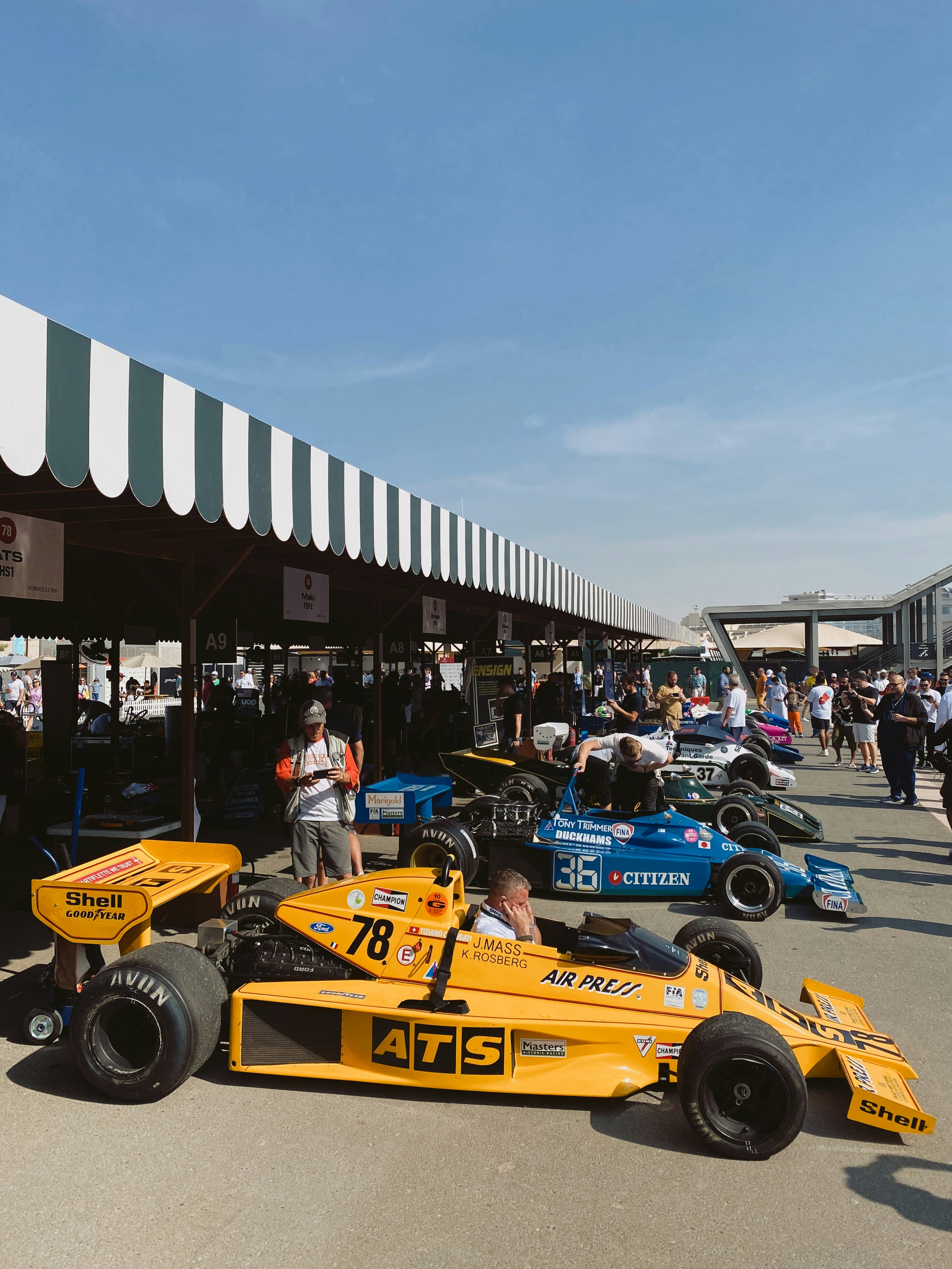 Eine Gruppe von Menschen, die um einen Rennwagen herum stehen