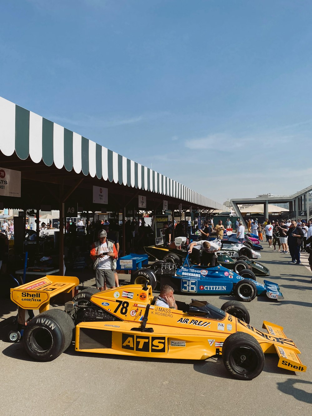 a group of people standing around a race car