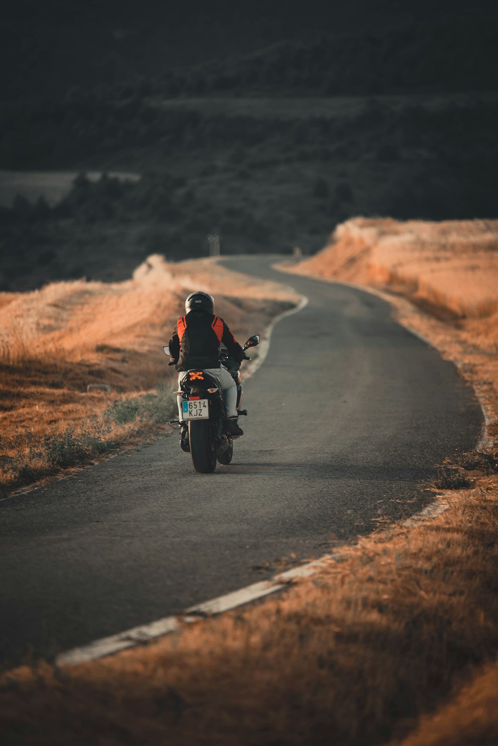 a man riding a motorcycle on a dirt road