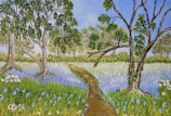 A serene landscape painting depicting a path winding through a vibrant field of wildflowers, surrounded by lush trees under a clear blue sky. The flowers are predominantly blue, interspersed with green grass. The trees have thick trunks and branches with abundant green leaves.