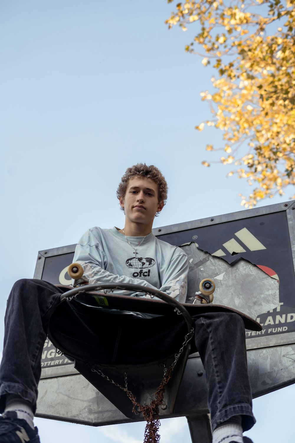 a man sitting on a bench with a skateboard