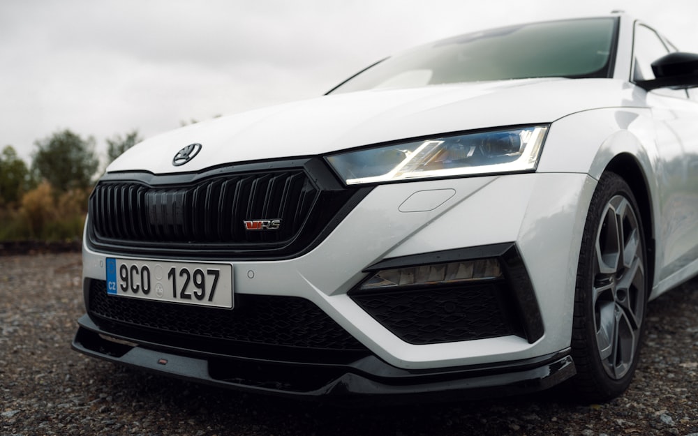 a white car parked on a gravel road