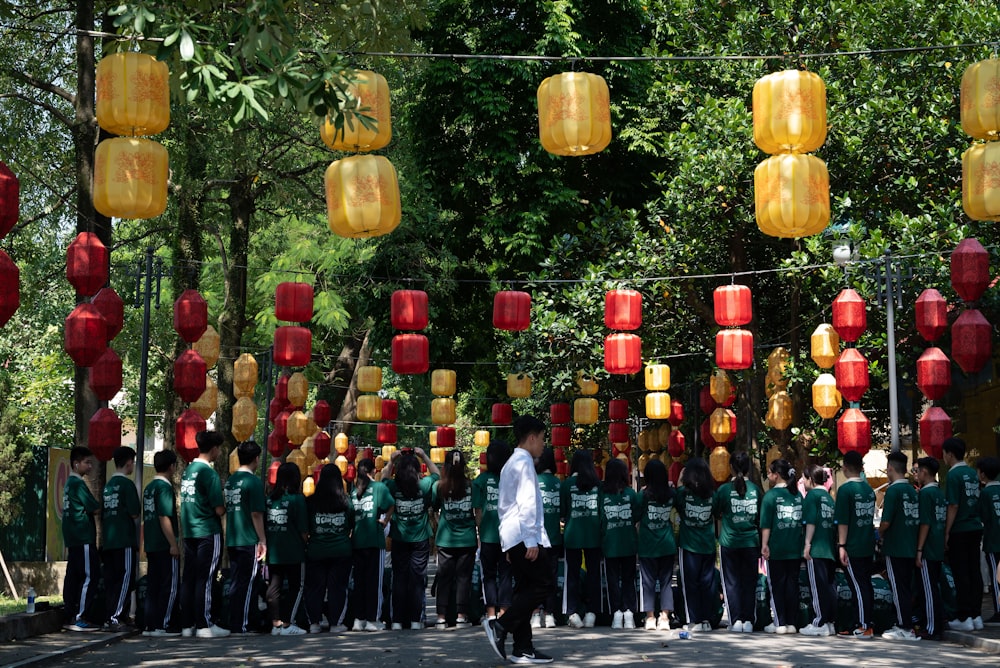 a group of people standing under lanterns