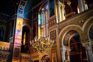 a large ornate chandelier in a large room with stained glass windows