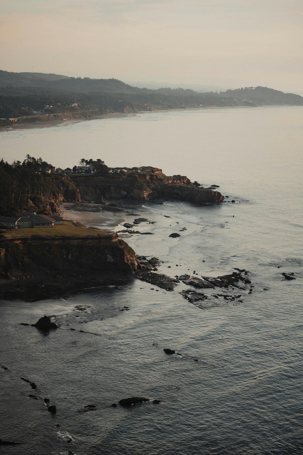 a rocky beach with a town on the other side of it