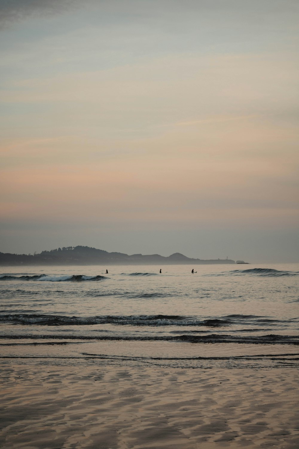 a beach with waves and a body of water