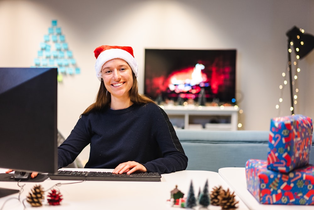 a person wearing a santa hat and sitting at a computer