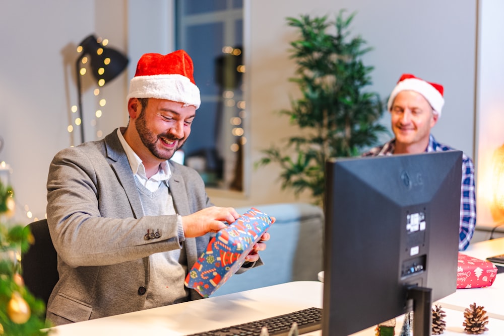 a man in santa hat holding a gift box