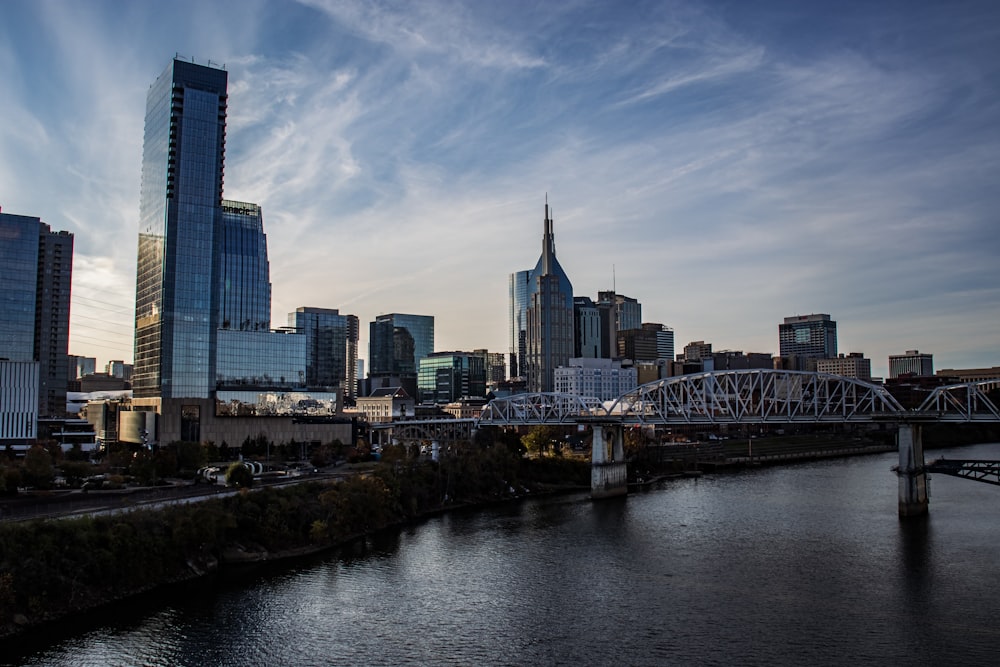 a bridge over a river with a city in the background