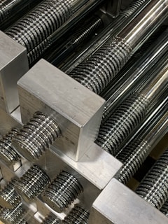 An organized shelf displaying an assortment of threaded rods.