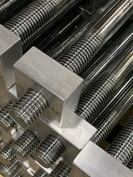 A close-up image of steel rods being precisely processed in a factory.