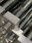 Close-up image of precision-machined aluminium rods stacked neatly in a workshop.