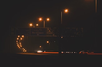 Nighttime shot of illuminated roadwork signs and reflective gear ensuring visibility and safety.