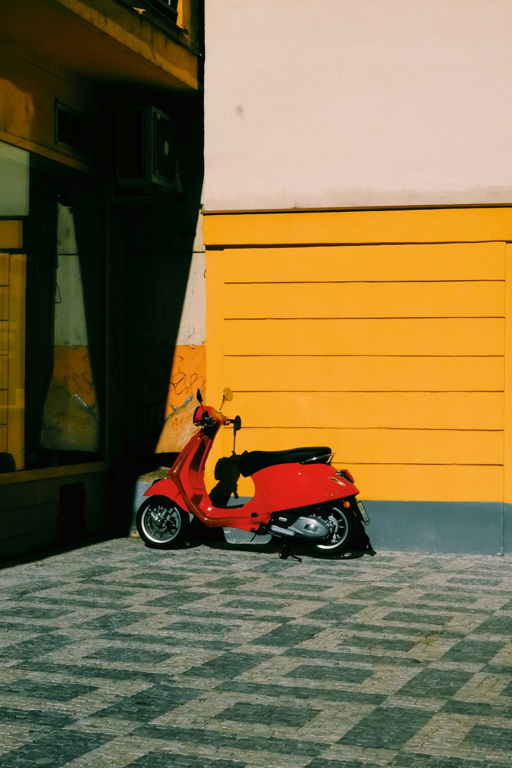 a red scooter parked outside a building