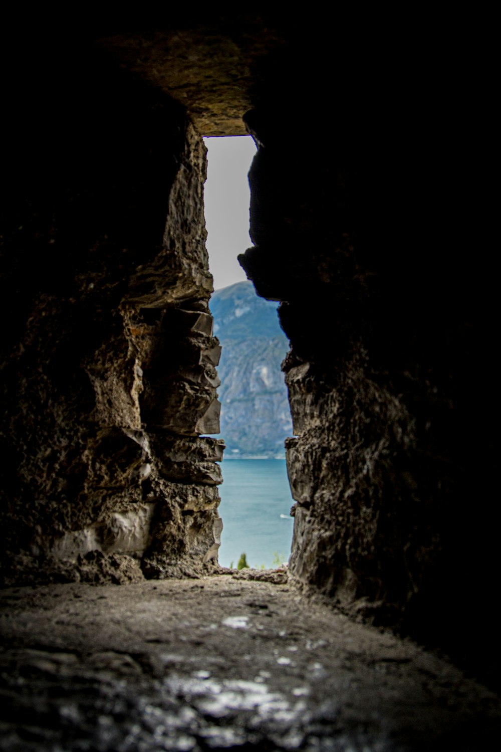 a cave with a view of the water and a bridge